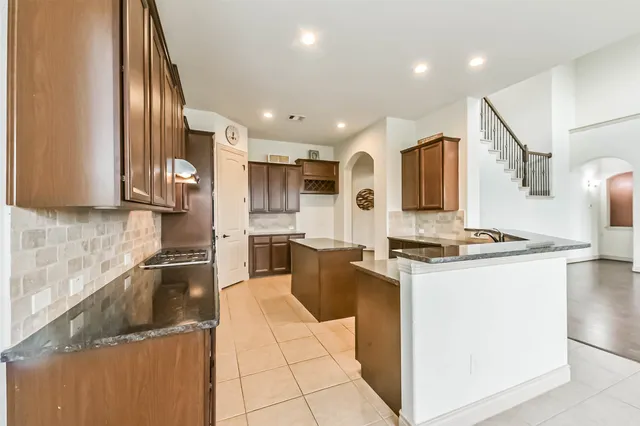 a kitchen with stainless steel appliances granite countertop a stove top oven and sink