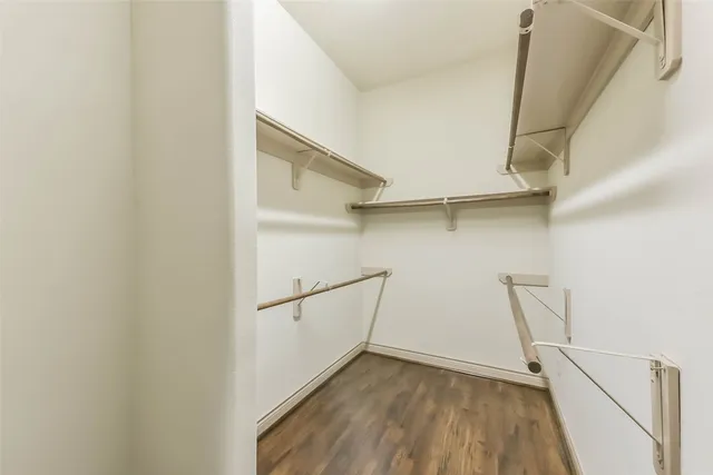 an empty room with a chandelier fan and windows