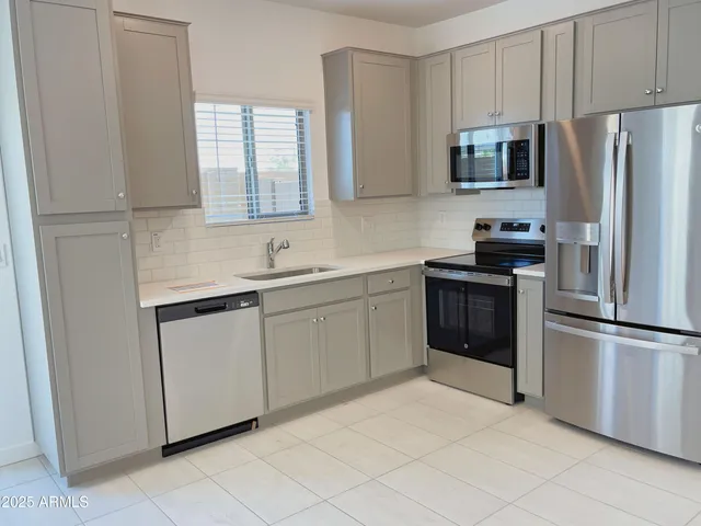a kitchen with white cabinets sink and stainless steel appliances