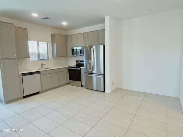 a kitchen with stainless steel appliances a refrigerator sink and cabinets