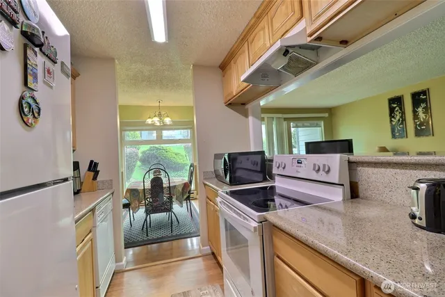 a kitchen with stainless steel appliances granite countertop a sink a stove and a refrigerator