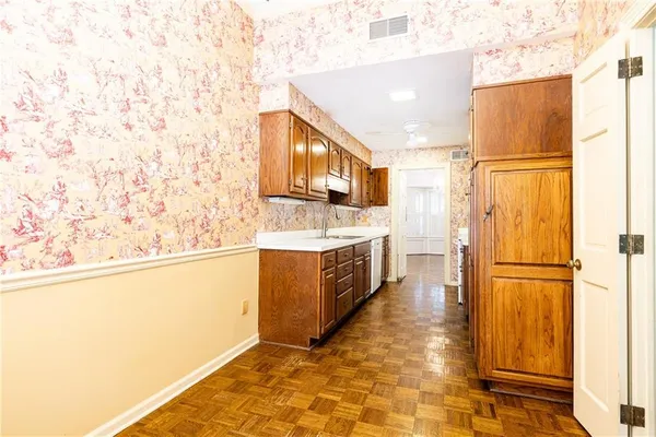 a large white kitchen with sink a refrigerator and a stove