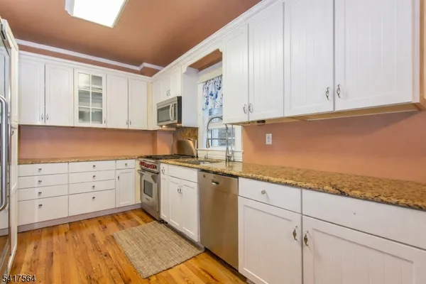 a kitchen with granite countertop cabinets stainless steel appliances and a sink
