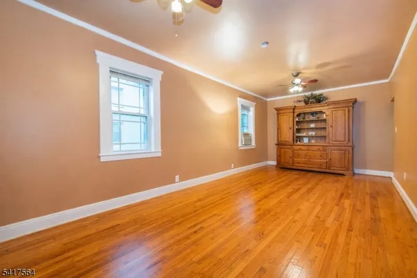 a view of an empty room with a window and wooden floor