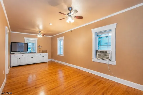 a view of an empty room with a window and a kitchen