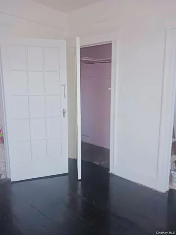 an empty room with wooden floor and closet