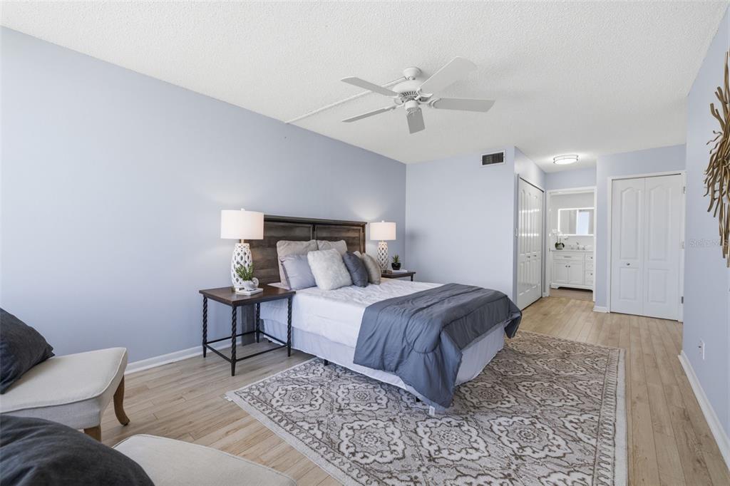 9495 Blind Pass Road, Unit 905 St. Pete Beach, FL 33706 - Photo 15 of 59 a spacious bedroom with a bed and a chandelier