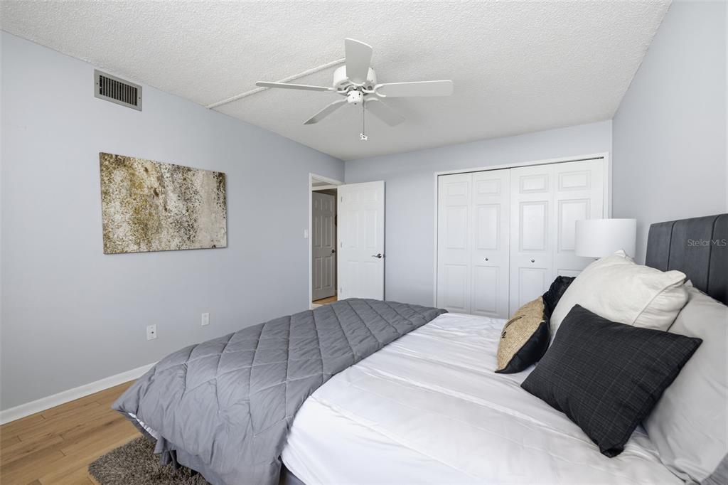 9495 Blind Pass Road, Unit 905 St. Pete Beach, FL 33706 - Photo 18 of 59 a bedroom with a bed and a chandelier