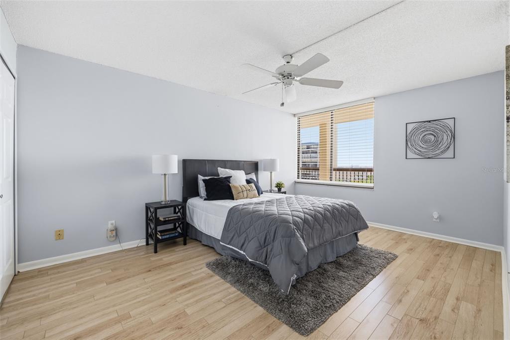 9495 Blind Pass Road, Unit 905 St. Pete Beach, FL 33706 - Photo 19 of 59 a bedroom with a bed and wooden floor