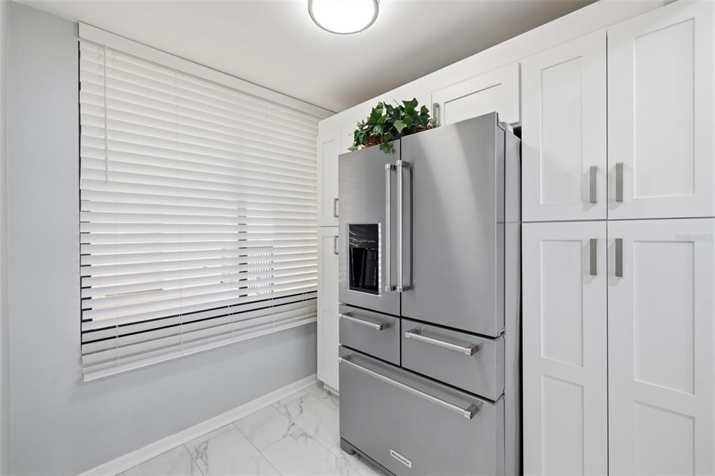 9495 Blind Pass Road, Unit 905 St. Pete Beach, FL 33706 - Photo 23 of 59 a white refrigerator freezer and a wooden floor