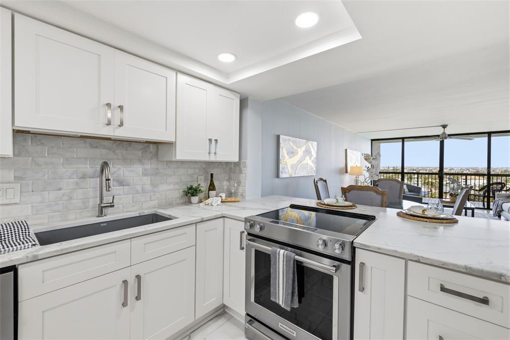 9495 Blind Pass Road, Unit 905 St. Pete Beach, FL 33706 - Photo 24 of 59 a kitchen with appliances a sink and cabinets