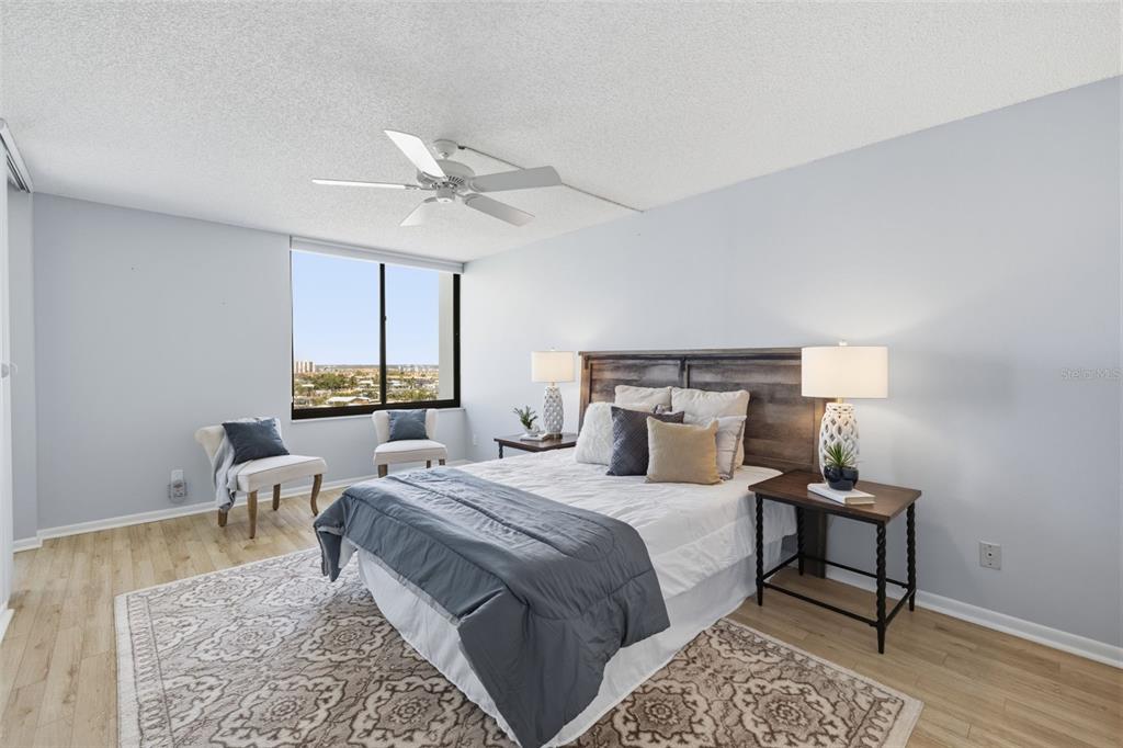 9495 Blind Pass Road, Unit 905 St. Pete Beach, FL 33706 - Photo 5 of 59 a bedroom with a large bed and wooden floor