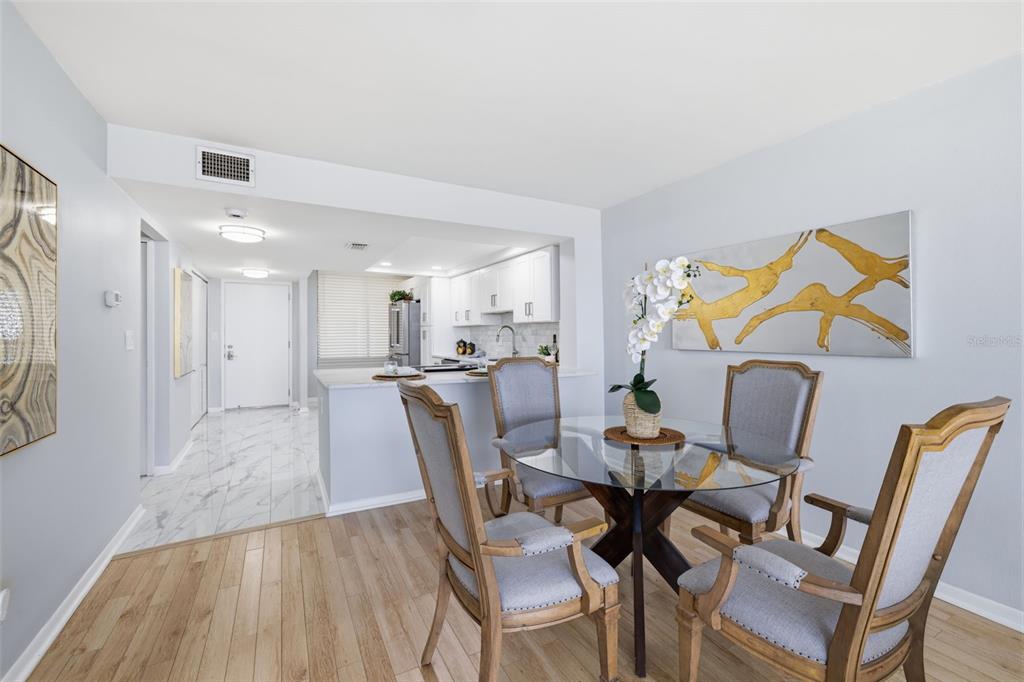 9495 Blind Pass Road, Unit 905 St. Pete Beach, FL 33706 - Photo 9 of 59 a view of a dining room with furniture and wooden floor