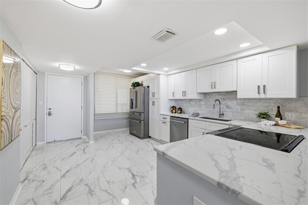 9495 Blind Pass Road, Unit 905 St. Pete Beach, FL 33706 - Photo 10 of 59 a kitchen with refrigerator cabinets and a sink