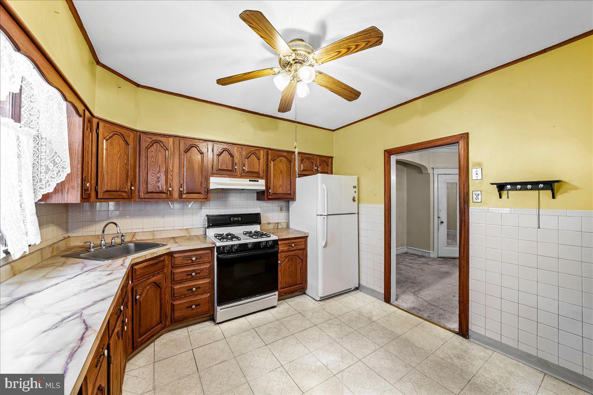 217 Avon Road Upper Darby, PA 19082 - Photo 9 of 16 a kitchen with stainless steel appliances granite countertop a stove refrigerator sink and dishwasher with wooden floor