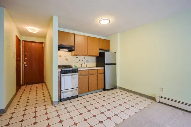 a kitchen with a refrigerator sink and cabinets