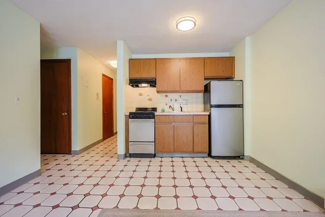 a kitchen with a refrigerator and cabinets
