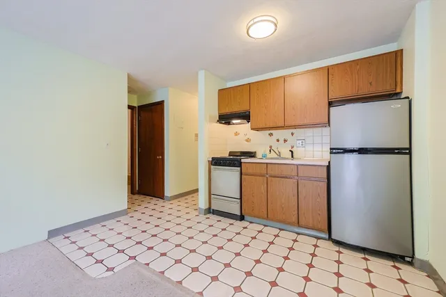 a kitchen with a refrigerator and cabinets