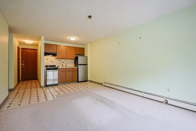 a view of kitchen with refrigerator stove and cabinets