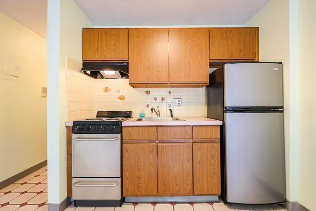 a kitchen with a refrigerator sink and cabinets
