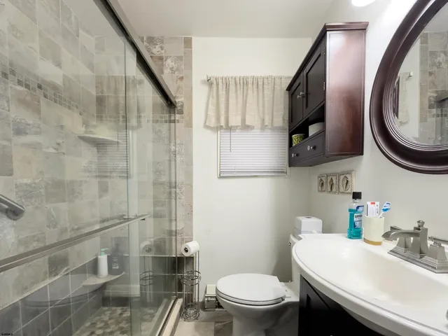 a bathroom with a sink a toilet and a mirror