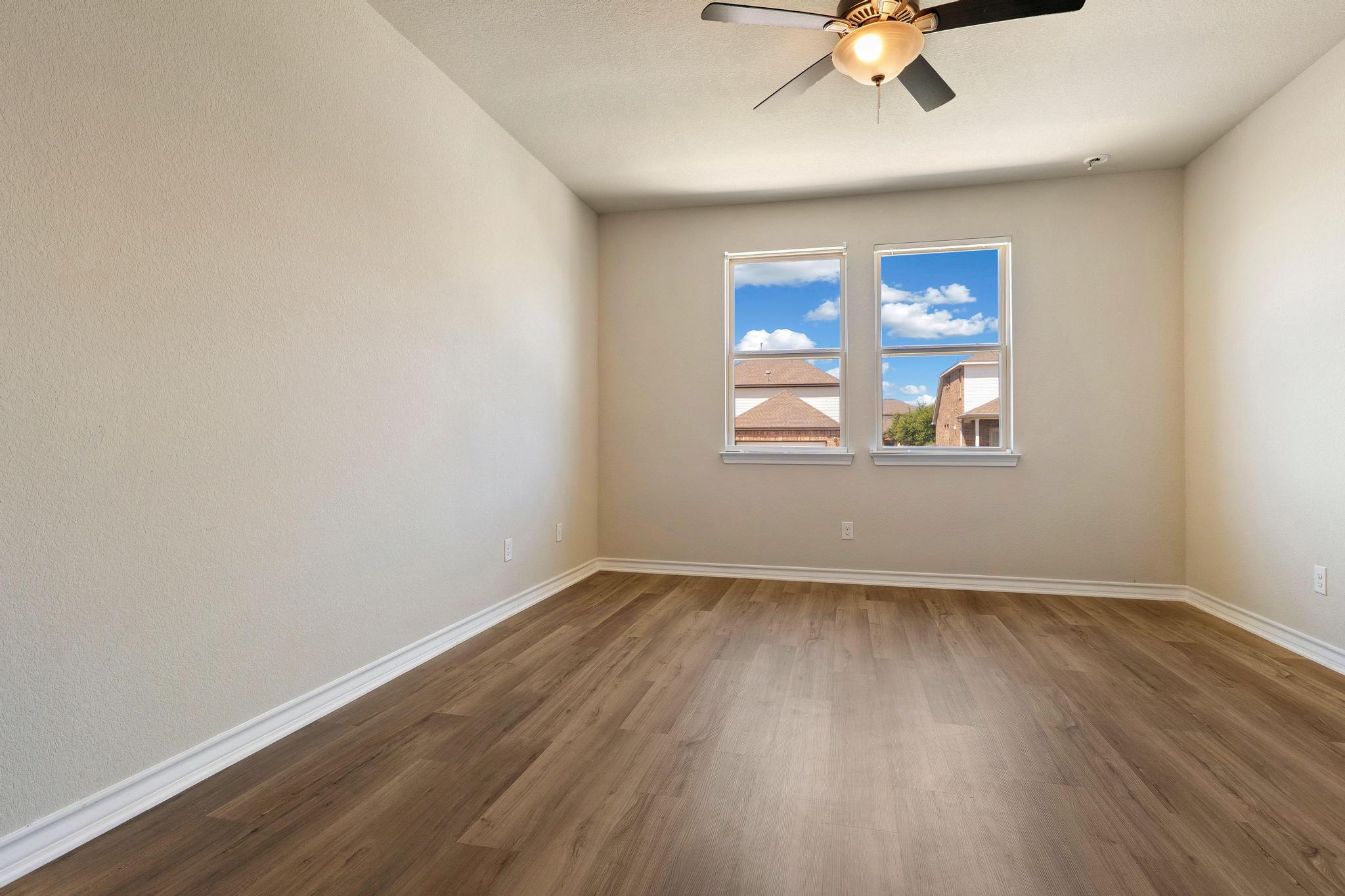1341 Eagle Ray Street Leander, TX 78641 - Photo 14 of 37 Well-lit room features rich hardwood flooring and a stylish ceiling fan for comfort.
