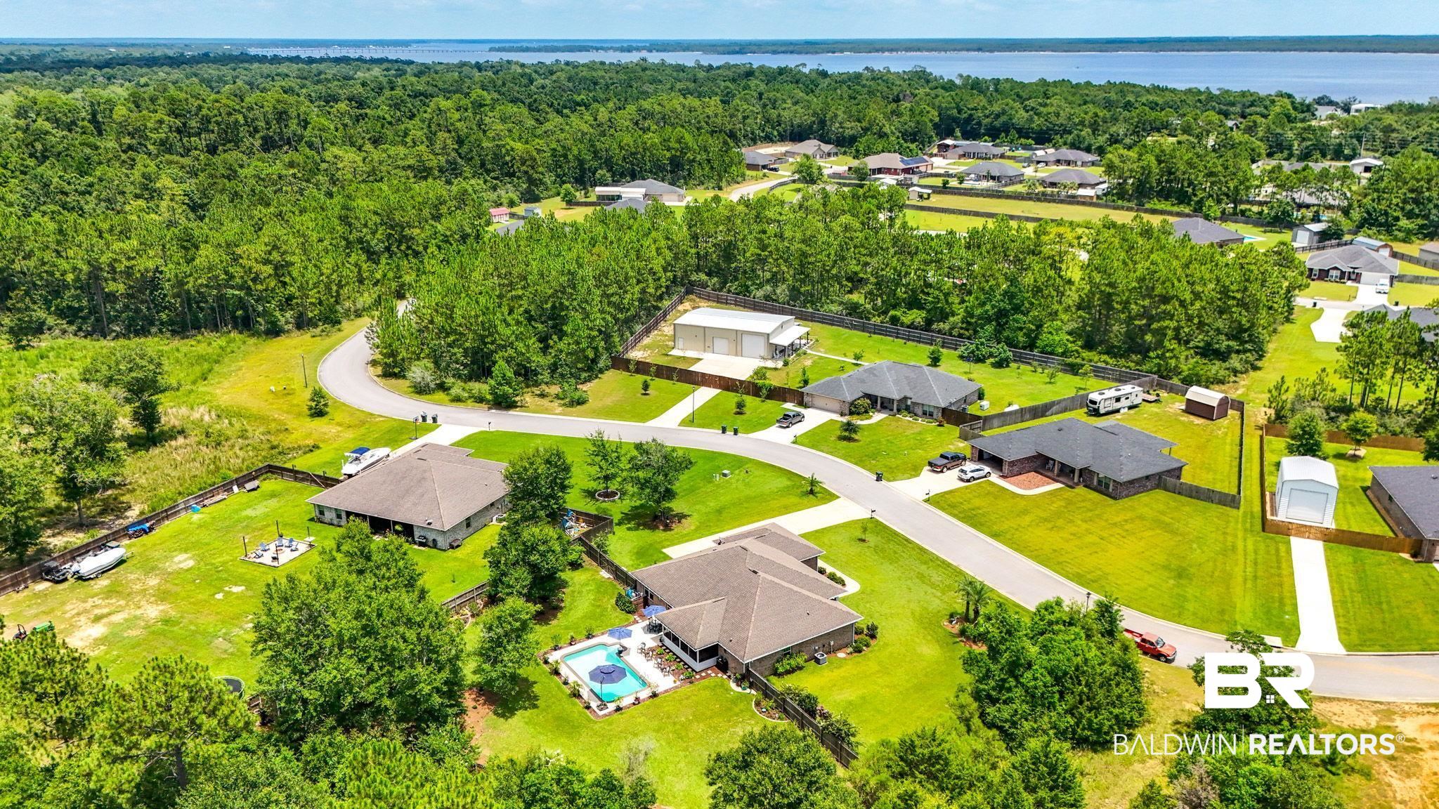 10473 Lyttleton Loop Lillian, AL 36549 - Photo 53 of 57 Aerial perspective of suburban area featuring a nearby body of water and a heavily wooded area