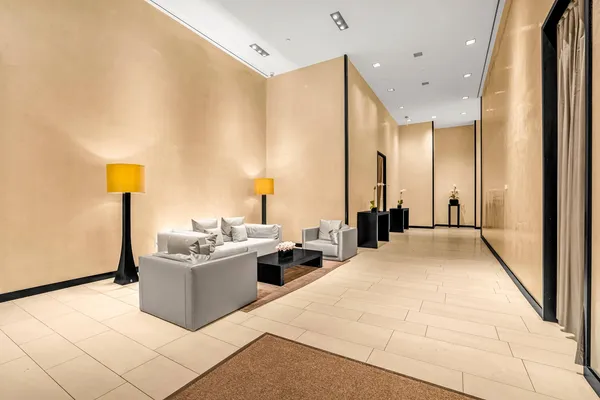 a living room with a sink furniture and a large mirror next to a window