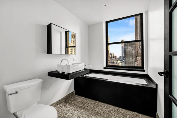 a bathroom with a toilet sink and mirror