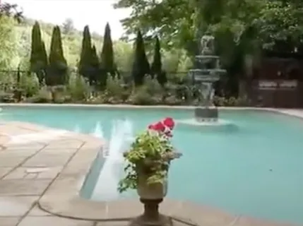 a view of a fountain in front of a house with a fountain