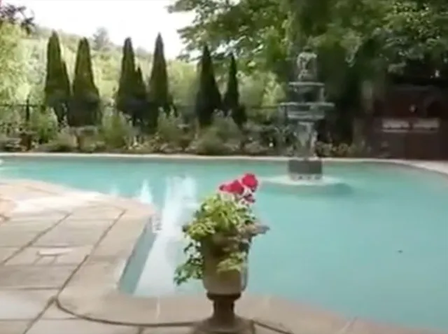 a view of a fountain in front of a house with a fountain