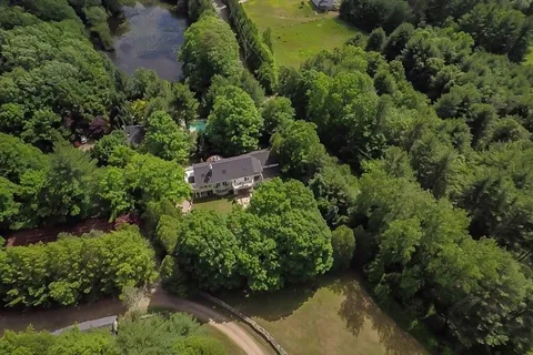 an aerial view of a house with a yard lake and lake view