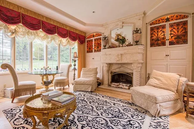 a living room with furniture a fireplace and a floor to ceiling window