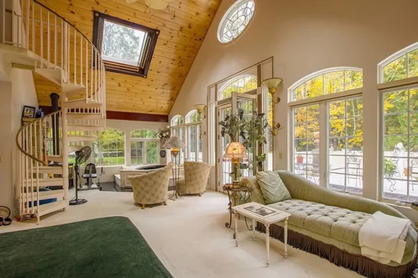 a bedroom with furniture and a large window