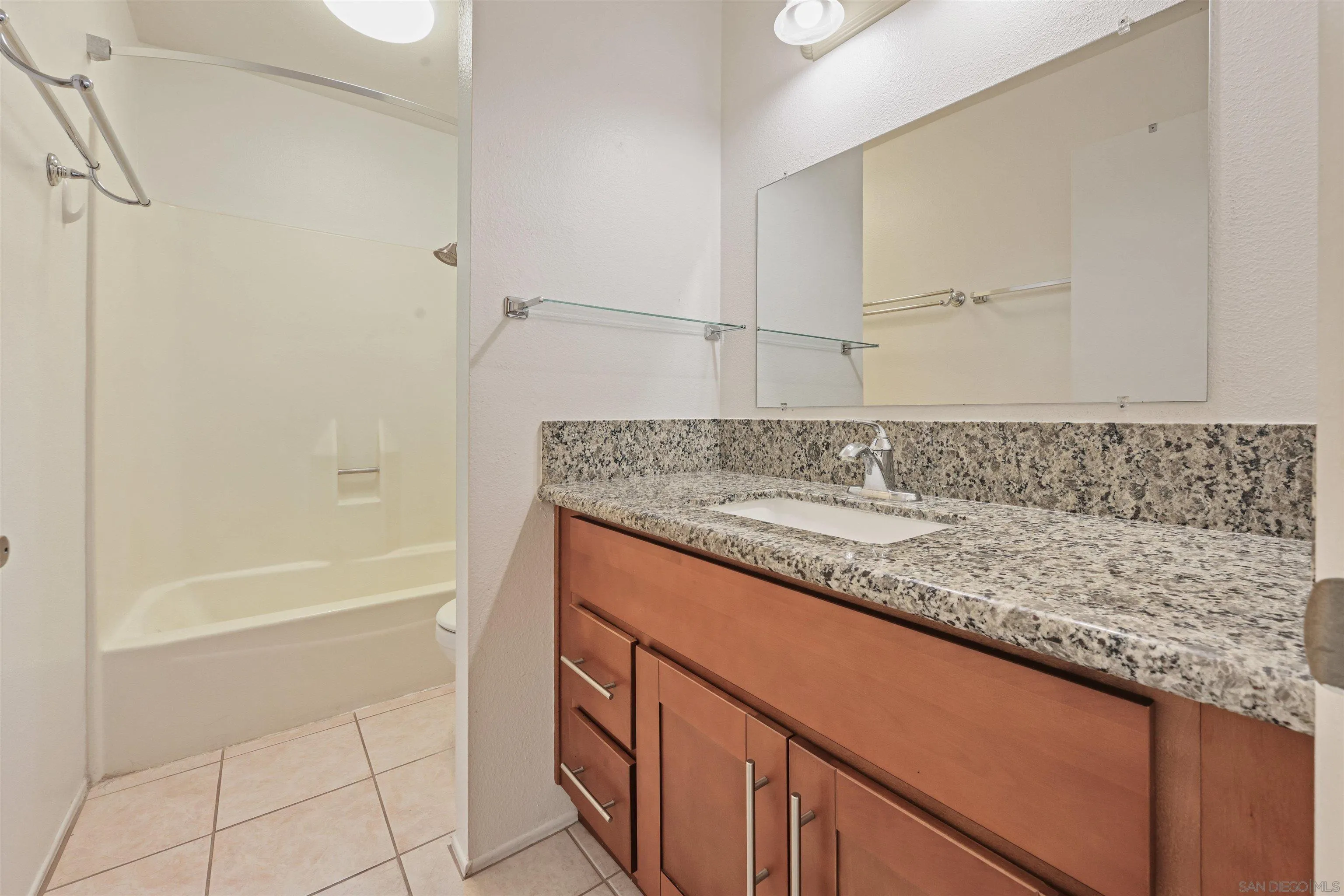 1652 Summertime Drive El Cajon, CA 92021 - Photo 11 of 23 a bathroom with a granite countertop sink a mirror and a bathtub