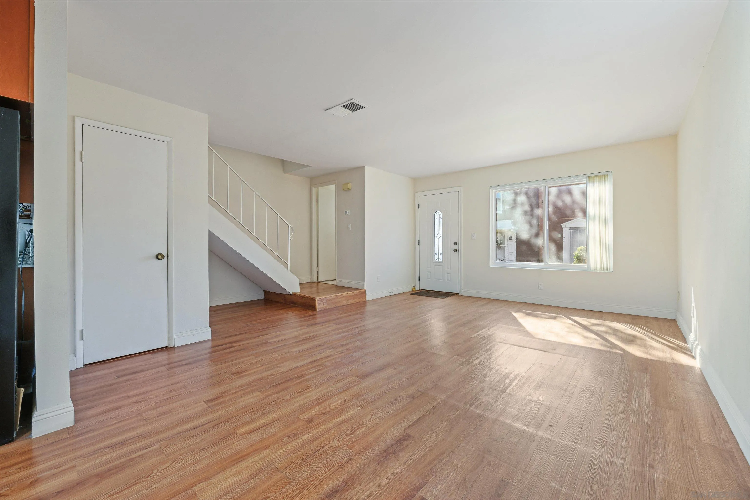 1652 Summertime Drive El Cajon, CA 92021 - Photo 4 of 23 an empty room with wooden floor cabinet and windows