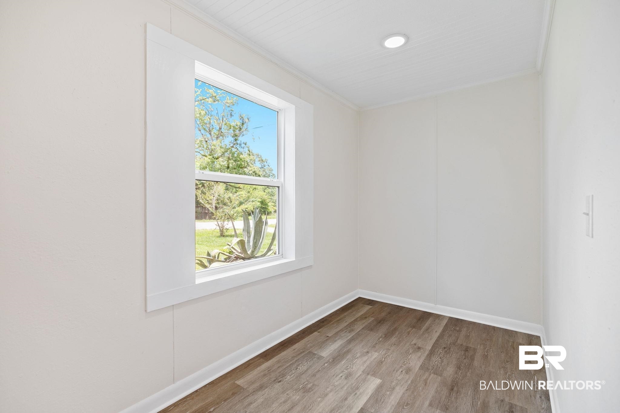 507 Byrne Street Bay Minette, AL 36507 - Photo 27 of 40 Unfurnished room featuring crown molding and hardwood / wood-style flooring