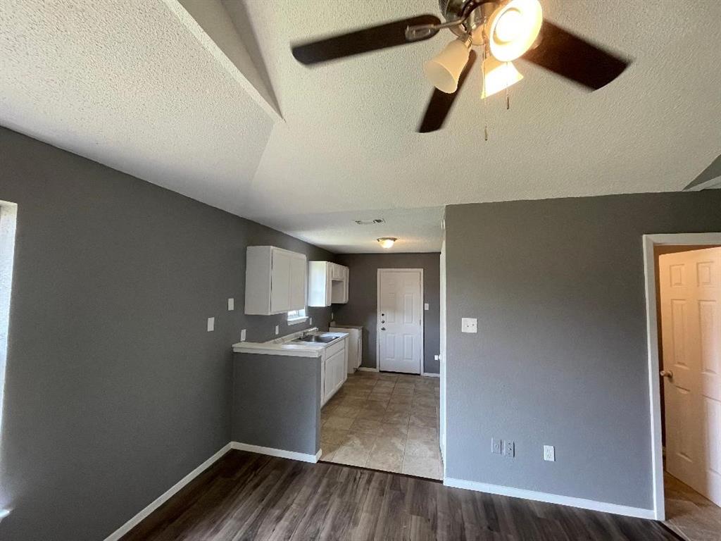 5338 Flamingo Road Fort Worth, TX 76119 - Photo 6 of 11 a kitchen with a wooden floor and a refrigerator
