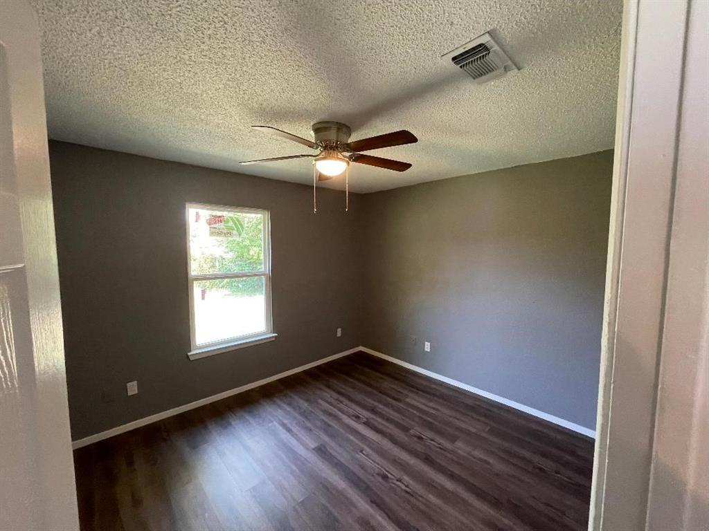 5338 Flamingo Road Fort Worth, TX 76119 - Photo 9 of 11 an empty room with wooden floor fan and windows