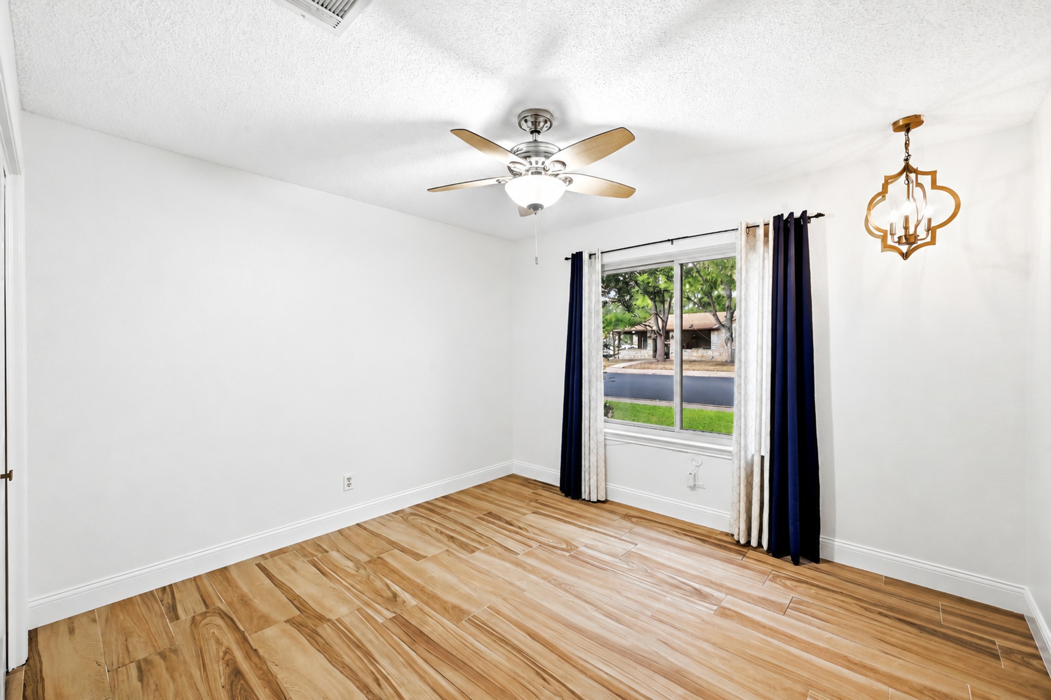 11218 Stormy Ridge Road Austin, TX 78739 - Photo 24 of 38 Warm wood-look tile flooring and a classic window set a serene tone in this bedroom.