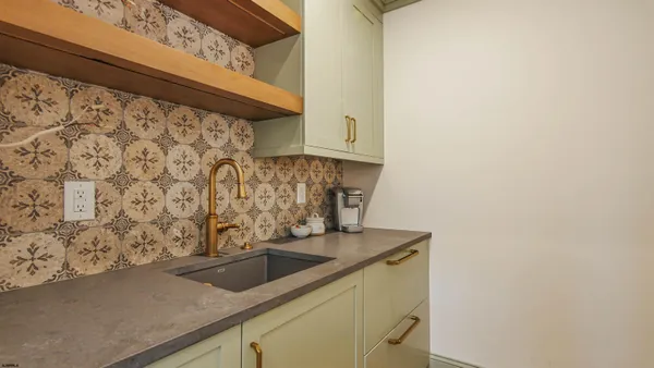 a bathroom with a granite countertop toilet sink vanity mirror and painting on the wall