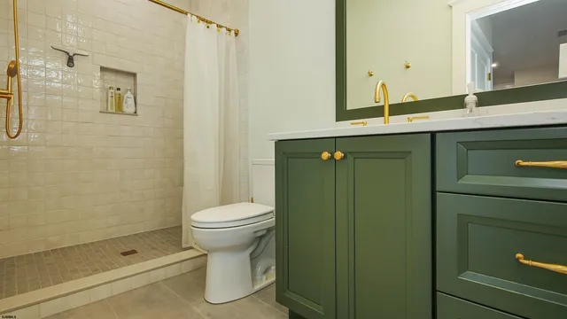 a bathroom with a shower a sink and a toilet