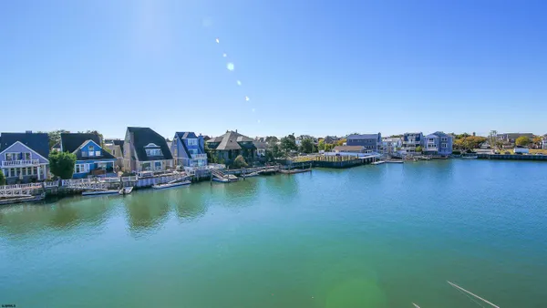 a view of an ocean with boats and trees in the background