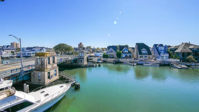 a view of an ocean with boats and trees in the background