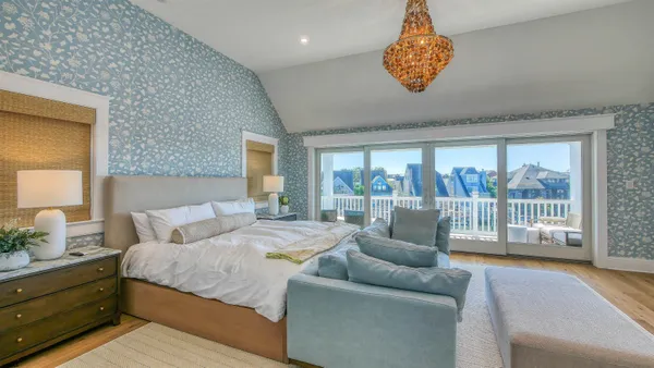 a large bedroom with a bed and glass window