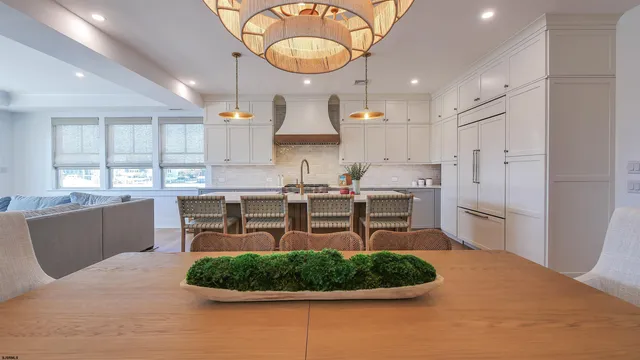 a kitchen with stainless steel appliances granite countertop a stove a refrigerator a sink dishwasher with a dining table and chair