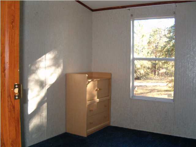 135 Henderson Road DeFuniak Springs, FL 32433 - Photo 6 of 14 a view of empty room with wooden floor and fan