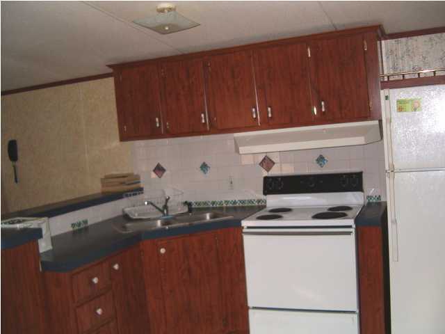 135 Henderson Road DeFuniak Springs, FL 32433 - Photo 9 of 14 a kitchen with granite countertop cabinets a sink and appliances