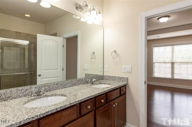 a bathroom with a granite countertop sink a large mirror and a window