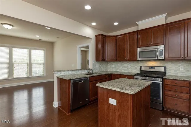 a kitchen with granite countertop wooden cabinets and a stove top oven